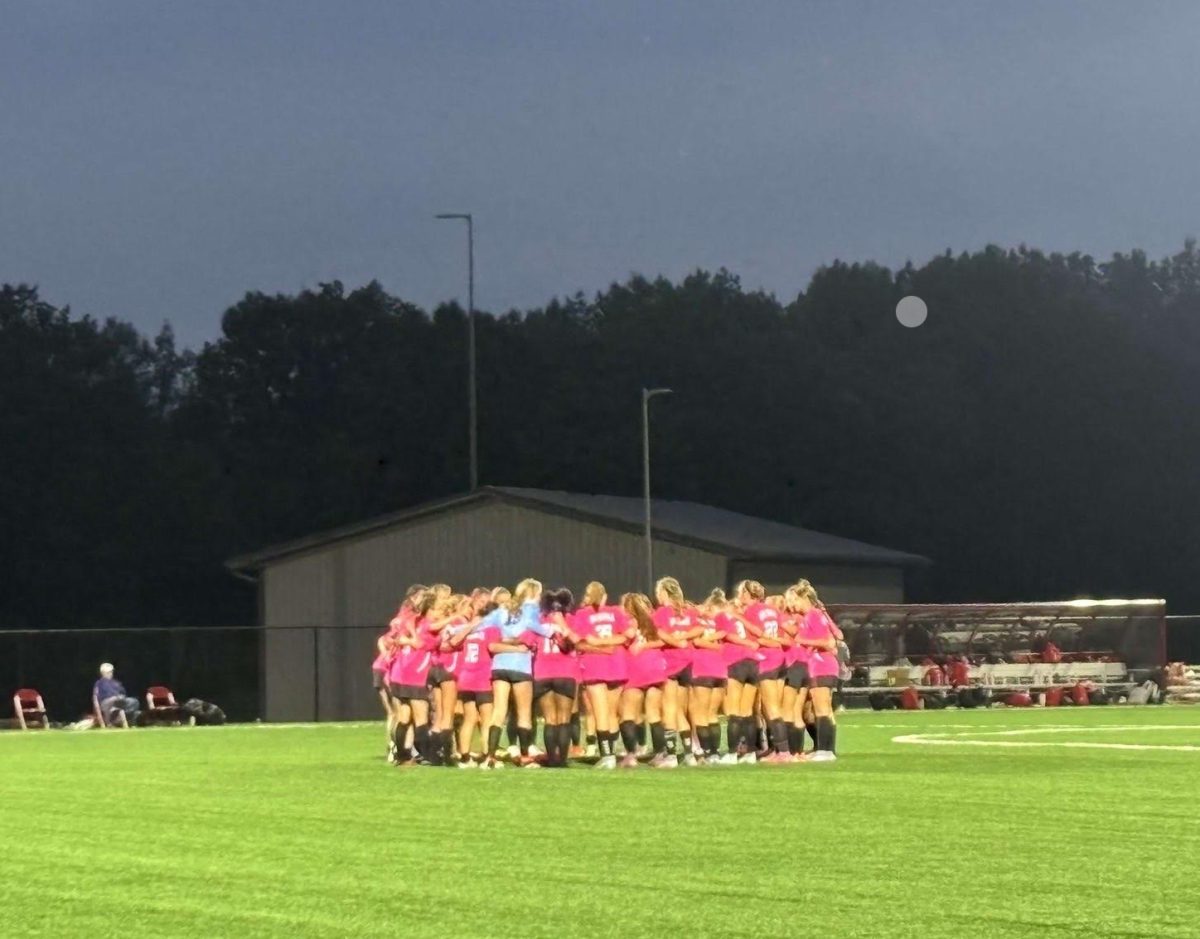 The entire Lady Red Devils take the field to do their signature chant before their game begins.