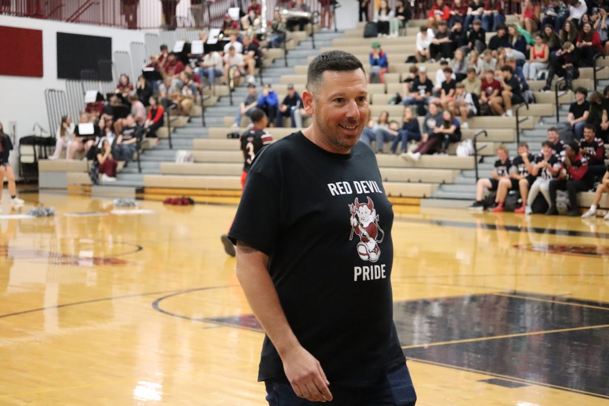 Mr. Mike McLindon walks off the court after giving a speech at the Homecoming Assembly.