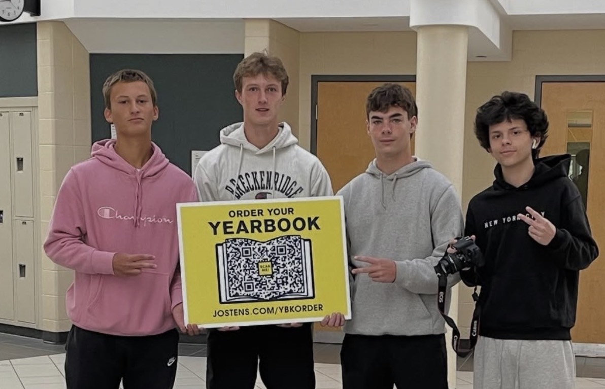 Hudson, Brody, Johnny, and Nate holding up a QR code to purchase a yearbook!